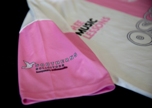 Image of the Limited Edition OssyFest Football Shirt, the shirt is pink and lemon yellow striped with the Southerns Solicitors logo on the sleeve.